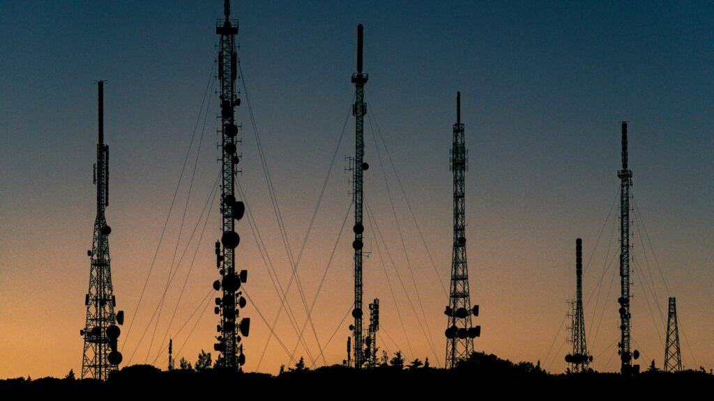 Torres de telecomunicaciones en paisaje al atardecer representando la infraestructura digital en Hispanoamérica