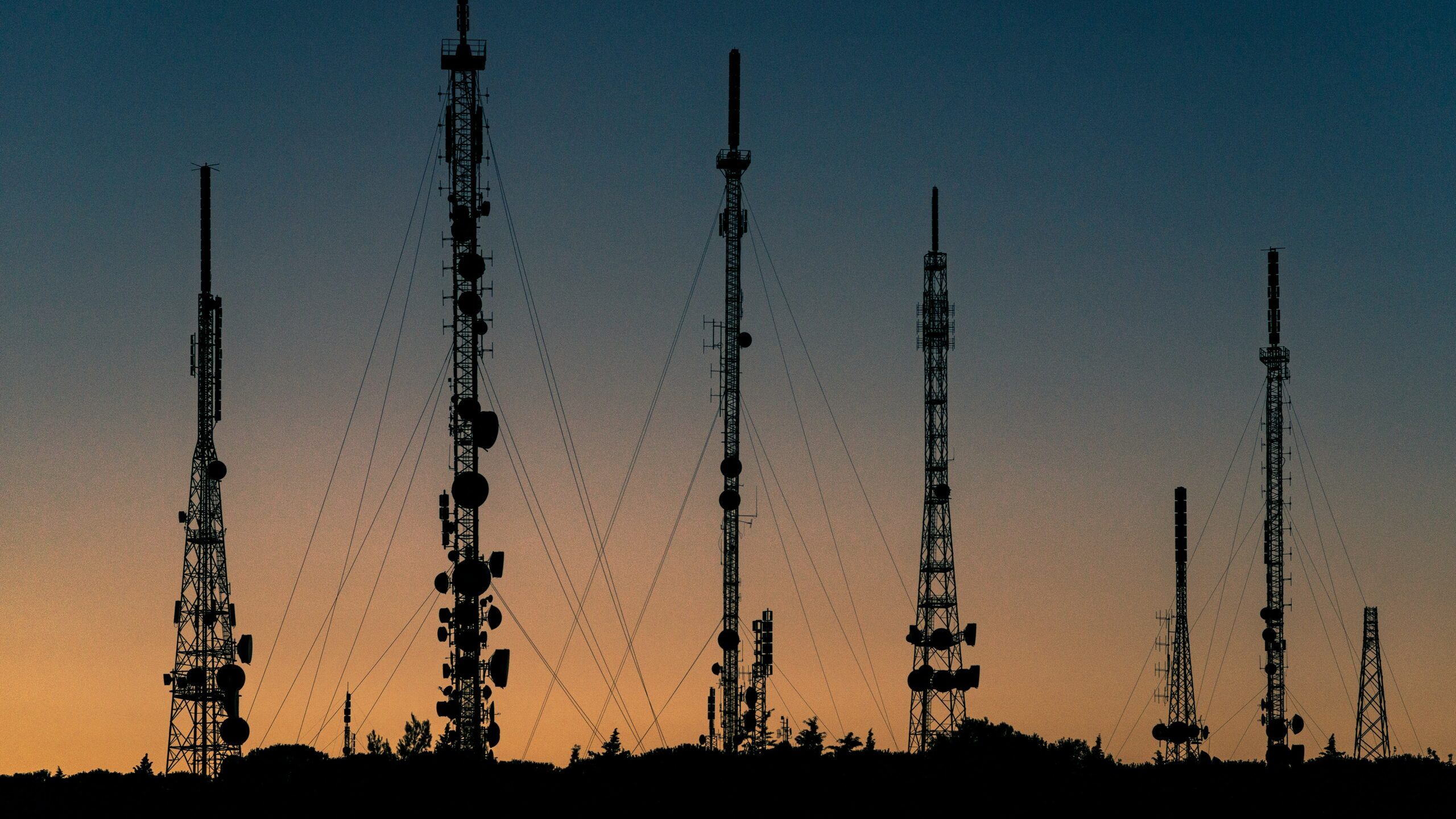 Torres de telecomunicaciones en paisaje al atardecer representando la infraestructura digital en Hispanoamérica