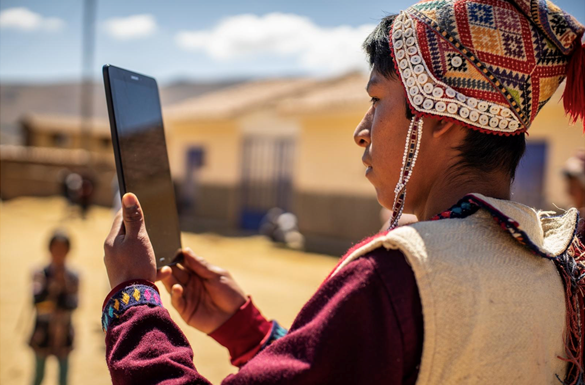 Mujer en zona rural del Perú utilizando una tablet gracias al acceso a internet de IPT